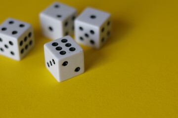 Una toma de cerca  de uno o varios dados blancos para juego en un fondo amarillo