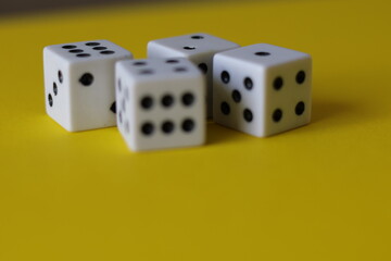 Una toma de cerca  de uno o varios dados blancos para juego en un fondo amarillo