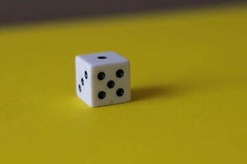 Una toma de cerca  de uno o varios dados blancos para juego en un fondo amarillo