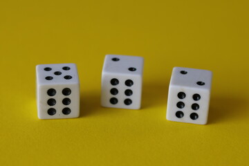 Una toma de cerca  de uno o varios dados blancos para juego en un fondo amarillo