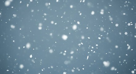 Fototapeta premium Softly falling white snowflakes against a muted blue winter sky background