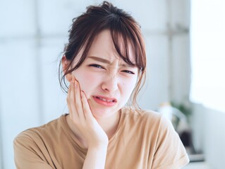 歯の痛みに顔をしかめる若い女性