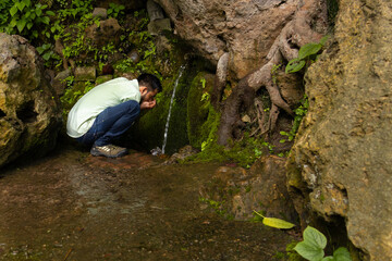 Man drinking fresh water from natural summer in Himalayas