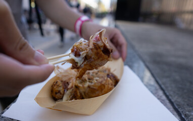 Takoyaki picked up by wooden sticks