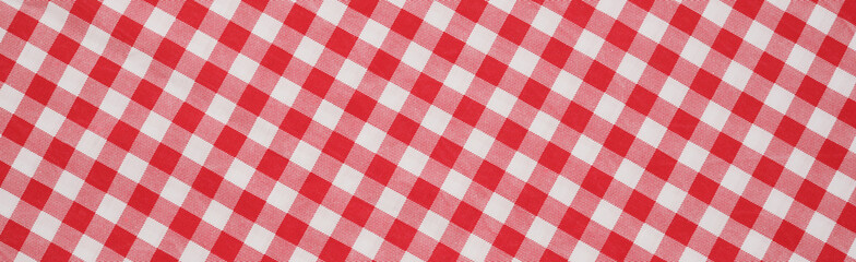 Closeup of a red and white checkered napkin or tablecloth texture. picnic cloth crumpled. Food decor element. Kitchen accessories. Top view background.