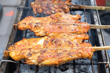 Juicy chicken over charcoal with smoke rising amid. The smoked roasted food is delicious. Street...