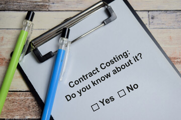 Contract costing do you know about it write on clipboard isolated on Wooden Table. A person is answering question concept