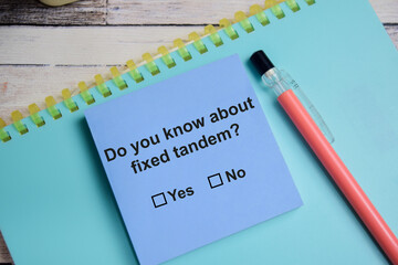 DO you know about fixed tandem write on sticky notes isolated on Wooden Table. A person is...