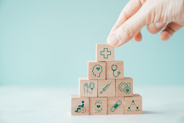 Hands holding wooden blocks with health care icons, healthcare, care plan, wellness center
