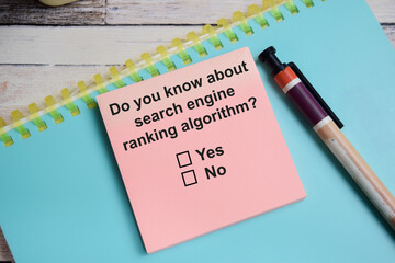 Do you know about search engine ranking algorithm write on sticky notes isolated on Wooden Table. A...