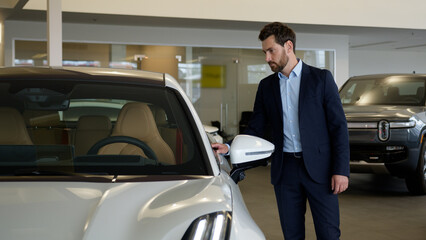 Caucasian man businessman touching car thinking client buyer automobile choosing choose rental...