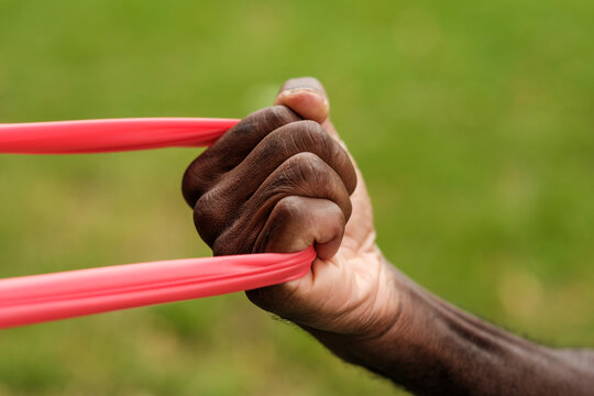 Senior man exercising hand with resistance band outdoors