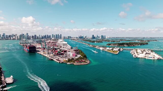 Miami, Florida, USA - April 10, 2025: Miami aerial view. Aerial view on CMA CGM cargo ship in port. Miami port. Cargo port with container ship. Port of Miami. Dodge island and cityscape