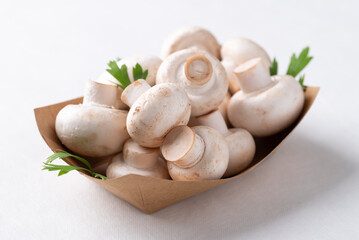 White Button mushroom or Champignon mushroom (Agaricus bisporus) in paper bowl, Food ingredient