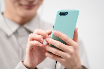 有線イヤホンで音楽を聴く若い男性