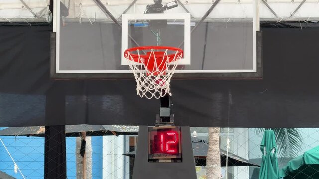 Basketball ball hitting the hoop with timer showing 6 seconds during indoor arcade game