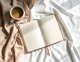 A serene morning flat lay of a lined journal and a warm ceramic cup of coffee resting on cozy blush and white linen bedsheets.