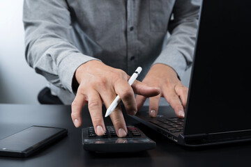 Businessman working with calculator and laptop for financial planning, accounting analysis and...