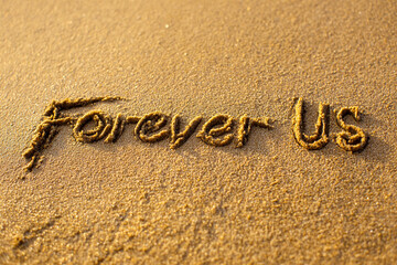 Fototapeta premium Forever Us Written in Golden Sand with Minimalist Hug Illustration and Gentle Wave in Loving Vertical Coastal Scene