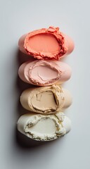 Four pastel-colored, textured oval-shaped objects stacked vertically against a white background