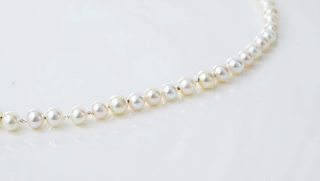 Delicate strand of small white pearls on a clean white background