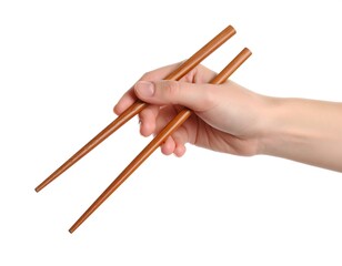A fair-skinned hand holds a pair of simple brown chopsticks against a white background