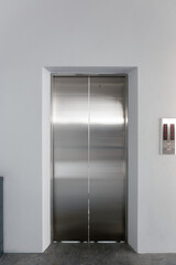 Front view of elevator door with clean concrete floor in a high-rise building. Represents architectural engineering design, utility infrastructure and vertical transportation. © DifferR