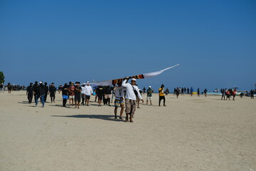 Group of boys carrying a large kite