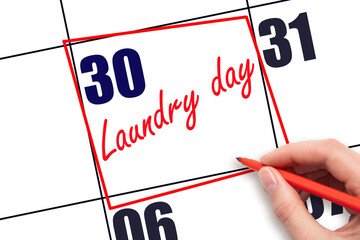 30th day of the month.  Hand writing Laundry day reminder and drawing red frame on calendar with...