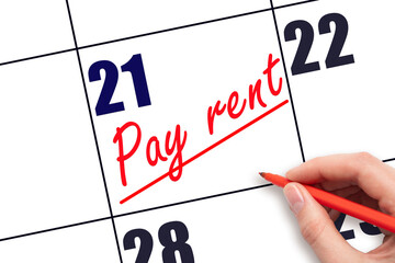 21st day of the month.  Hand writing Pay rent reminder and drawing a line on calendar with red pen...