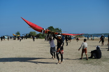 Group of boys carrying a large kite
