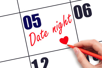5th day of the month.  Hand writing Date night reminder and drawing a red heart on calendar with...