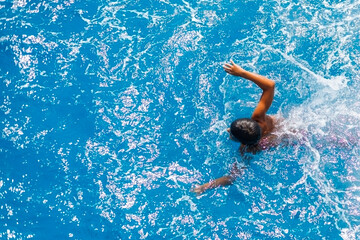 Child swimming in bright blue sea