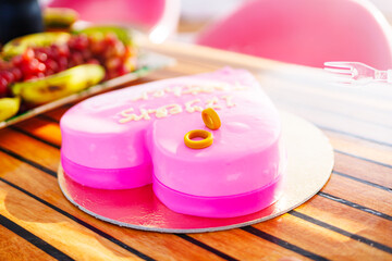 Heart-shaped pink cake with rings on top