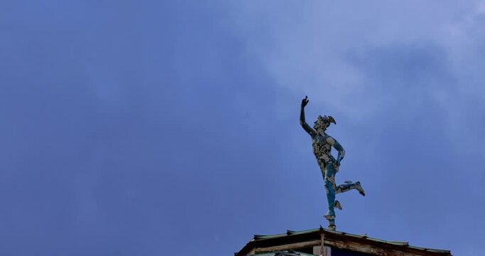 4K time-lapse of the Roman god Mercury statue atop the Winter Garden dome in Avery Hill Park, South East London, with drifting clouds and dynamic sky creating a historic, mythological scene