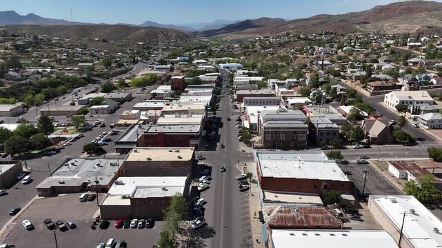 Drone Flying from South to North Broad street in Downtown Globe Arizona. Cars driving down street, mountains in background on a bright summer day