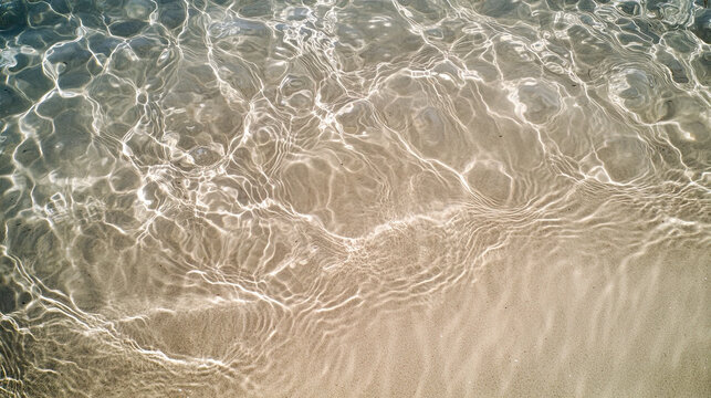 Clear shallow ocean water gently washing over white sand beach in sunlight, natural ripple texture and tropical shoreline background perfect for travel, wellness, and environmental design uses
