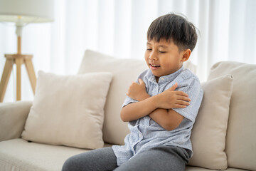 Asian boy feeling chills or sickness, recovering from illness, cold and unwell, child health care in winter, fever symptoms and rsv virus, health care, body cold at home