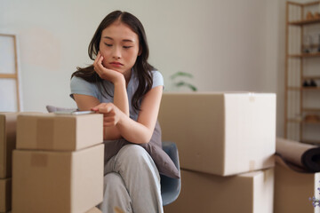 Asian adult woman experiences overwhelming moving day challenges feeling tired frustrated during...