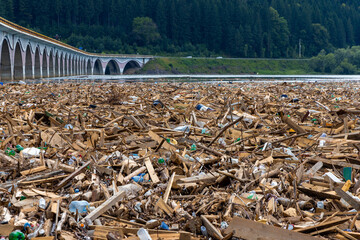 Lots of waste floating on the surface of the water. Various garbage on the surface of Lake Izvorul Muntelui - Romania brought by the flood