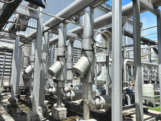 A complex and imposing industrial structure of large pipes and support columns in a factory or...