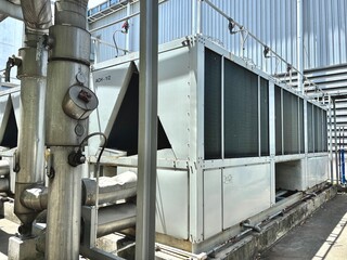 Large industrial cooling units or chillers outside a factory or power plant. The extensive metallic...