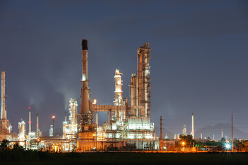Petrochemical plant at night. Empty copy space on sky suit for concept of price, market. Machine equipment and pipeline to processing for oil refinery, petrol or fuel production.