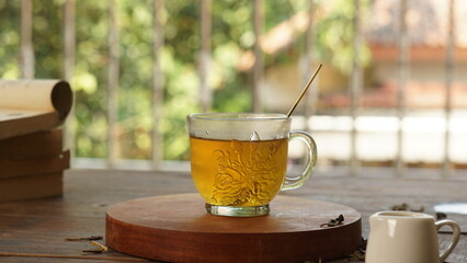 cup of tea, tea being poured into a transparent and white tea cup, teapot and tea cup with floral motif, darmkmood tea photo display