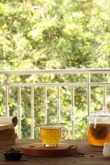 cup of tea, tea being poured into a transparent and white tea cup, teapot and tea cup with floral motif, darmkmood tea photo display