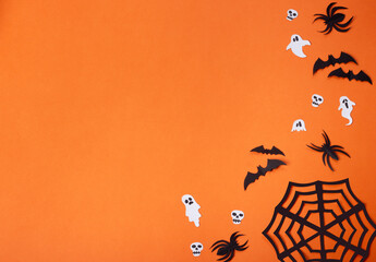 Halloween composition with spiders, bats, skulls and ghosts on orange background, with spider web...
