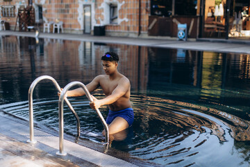 Swimmer exiting pool using ladder after training session