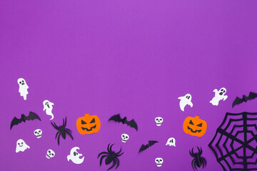 Paper crafts of pumpkins, skulls, ghosts, spiders and bats on purple background, halloween concept with copy space.