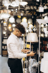 Man Shopping for Stylish Lamps in a Modern Lighting Store