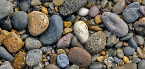 The colorful assortment of smooth stones on a natural surface.